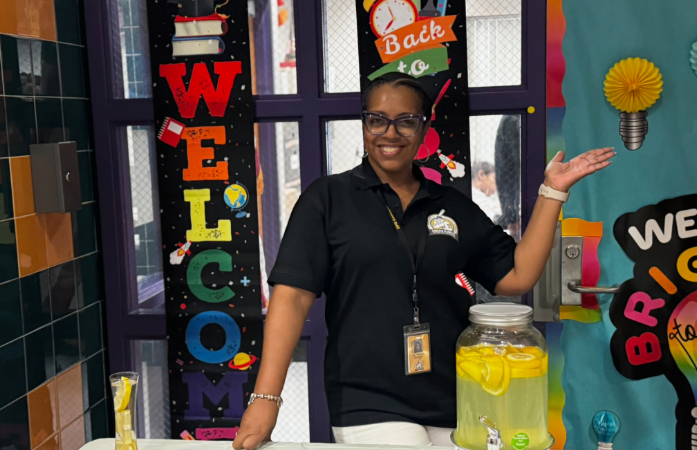  Teacher standing in front of the Welcome banner